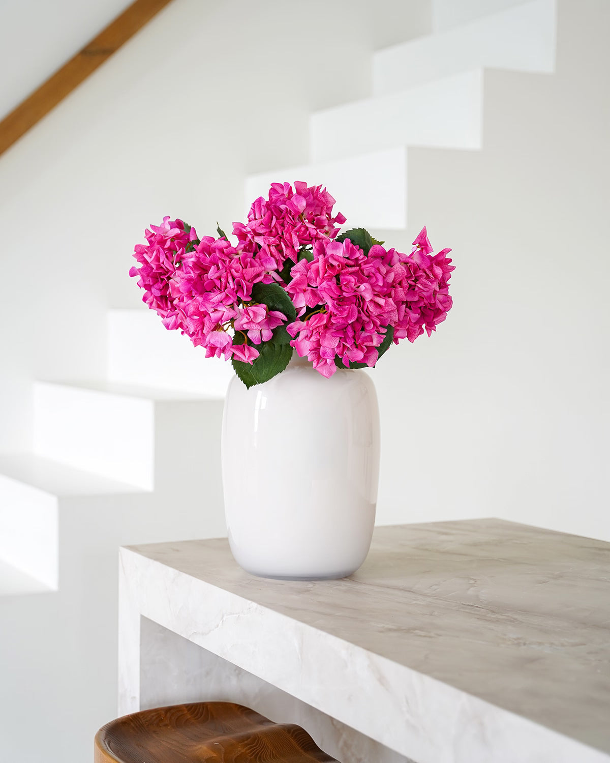 Hoofdafbeelding collectie zijden bloemen van Fan of Flowers: crème-witte vaas Crema gevuld met fuchsia roze zijden hortensia's.