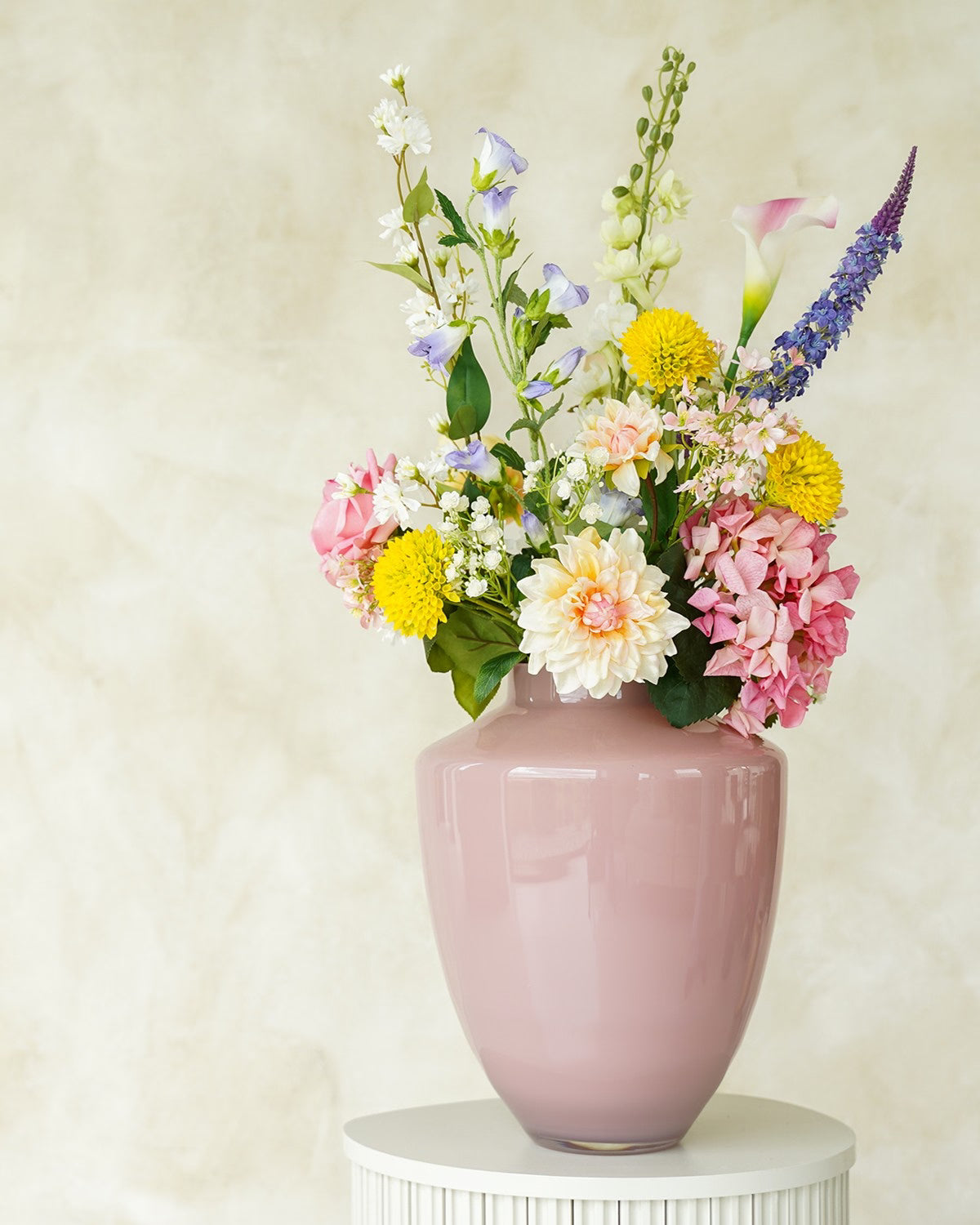 Vrolijk en kleurrijk zijden veldboeket Bella van Fan of Flowers gepresenteerd in lichtroze vaas Rosa.