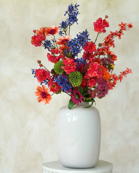 Kleurrijk zijden veldboeket Cielo van Fan of Flowers gepresenteerd in glanzend witte vaas Crema.