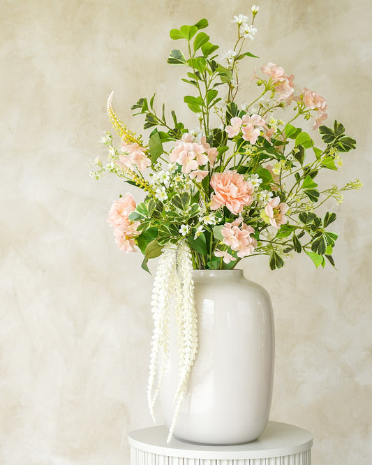 Zachtroze en verfijnd zijden boeket Perla uit de collectie van Fan of Flowers gepresenteerd in vaas Crema.