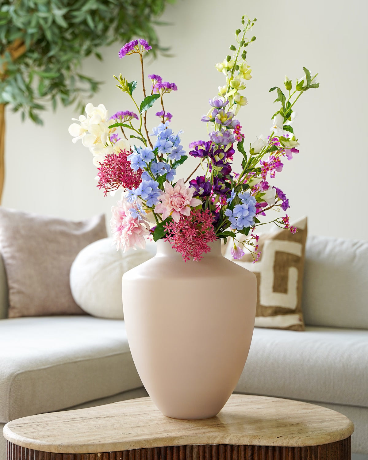 Kleurrijk zijden veldboeket Amatista van Fan of Flowers op de salontafel in een modern interieur.