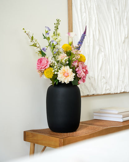 Zijden boeket Bella van Fan of Flowers in zwarte vaas Negro gestyled op een houten bankje in een modern interieur.