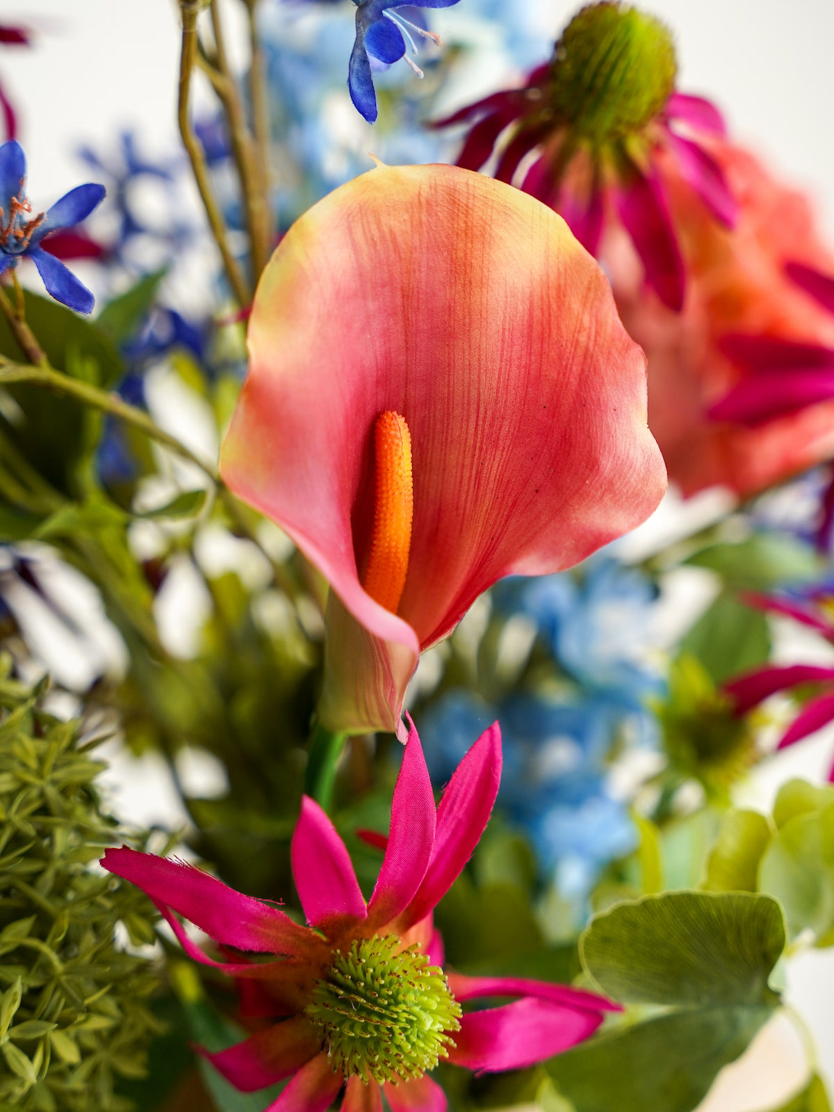 Close-up van de roze-oranje Calla in het kleurrijke zijden boeket Rubi van Fan of Flowers.