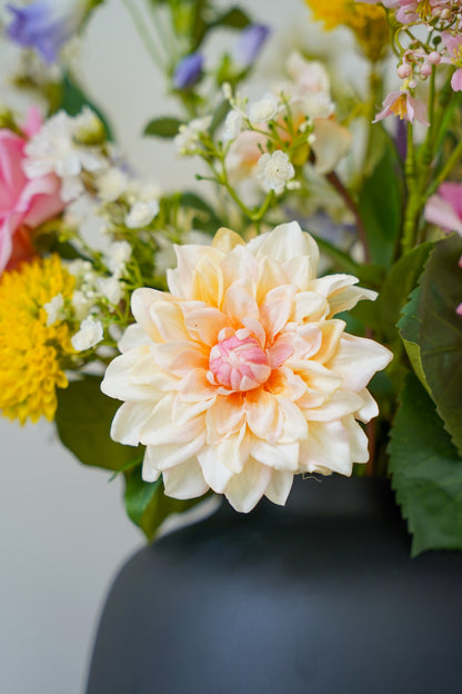 Close-up van een perzikroze zijden dahlia uit het kleurrijke boeket Bella van Fan of Flowers.