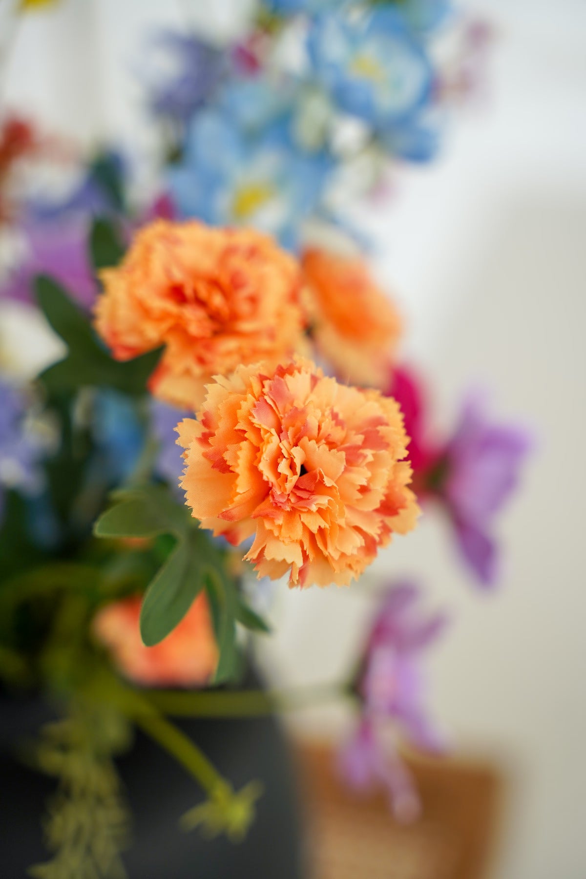 Close-up van verfijnde oranje zijden anjers uit het boeket Fiera van Fan of Flowers.