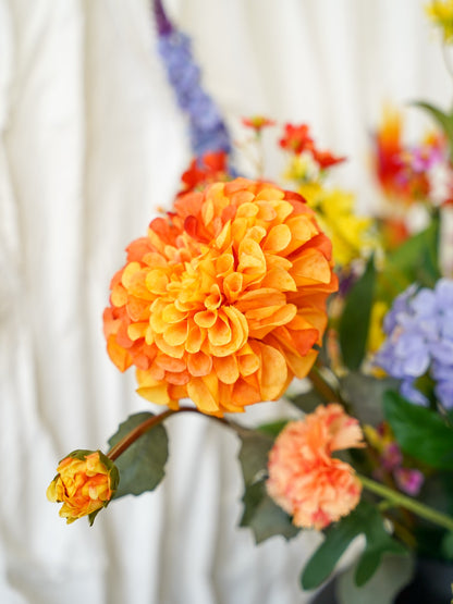 Close-up van de warme oranje zijden dahlia in het kleurrijke boeket Fiera van Fan of Flowers.