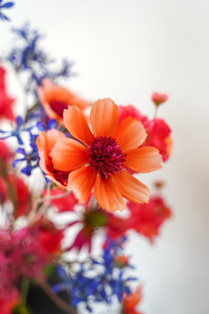Close-up van een oranje zijden snijbloem uit het kleurrijke boeket Cielo van Fan of Flowers.