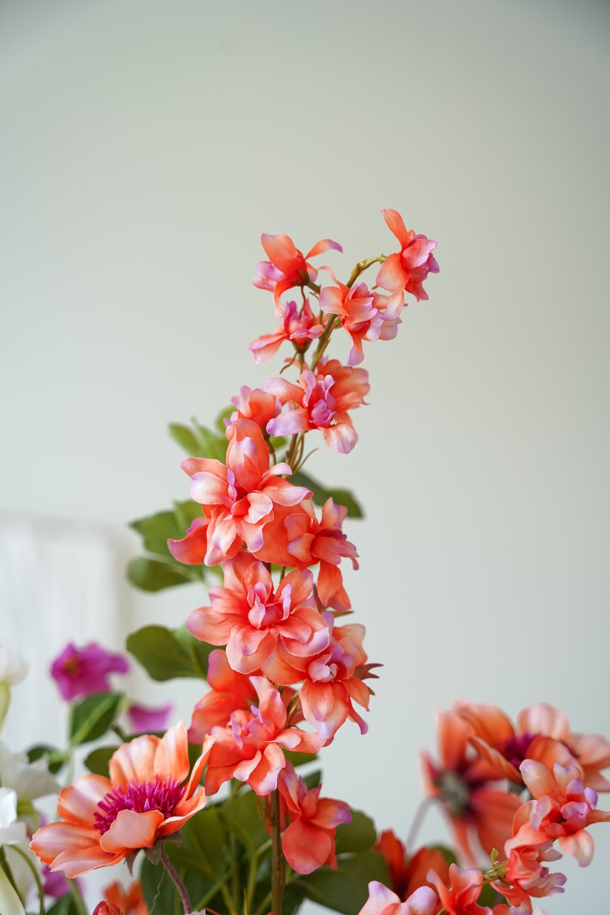 Detailopname van de verfijnde oranje bloemtakken uit het zijden boeket Vela van Fan of Flowers.