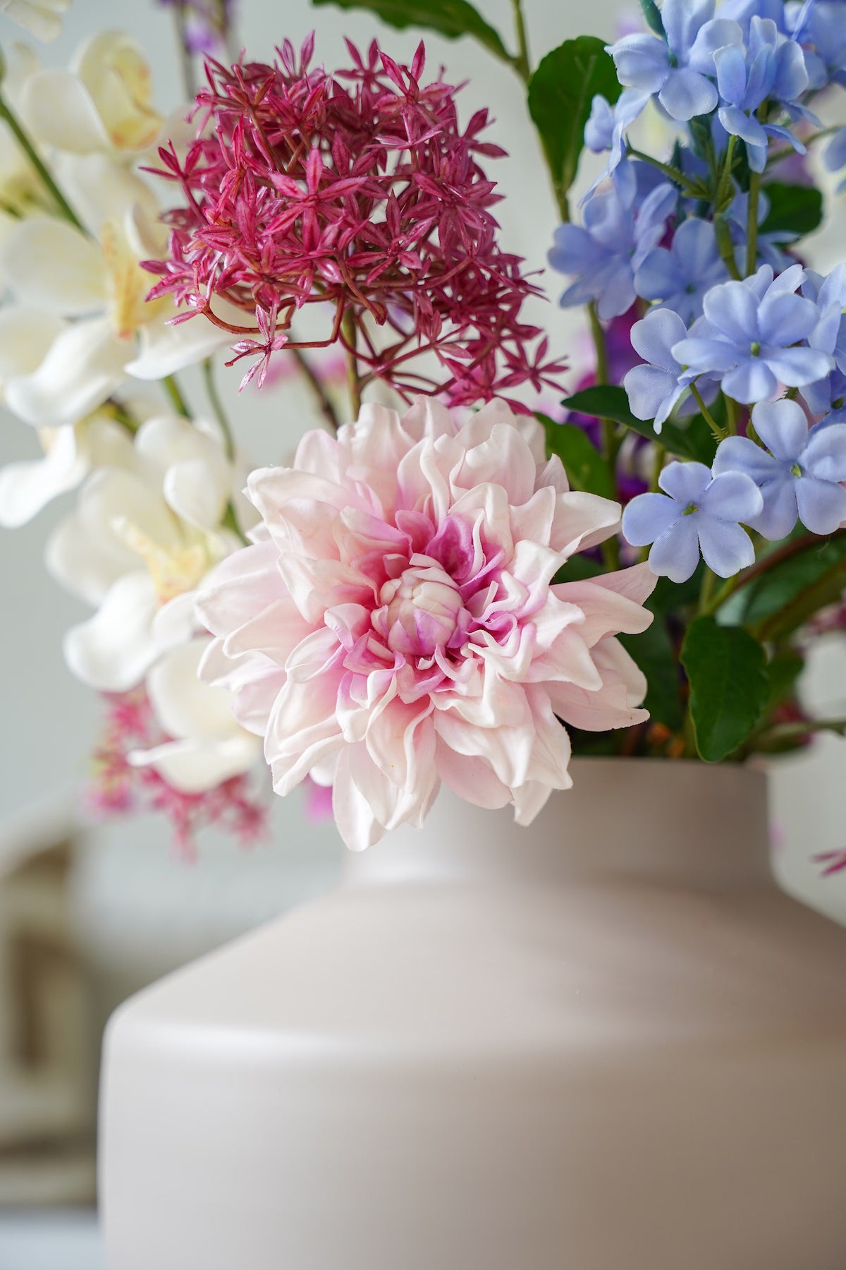 Detailopname van de verfijnde roze en blauwe zijden bloemen in boeket Amatista van Fan of Flowers.