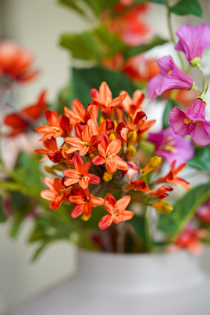 Close-up van de warme oranje en paarse zijden bloemen in boeket Vela van Fan of Flowers.