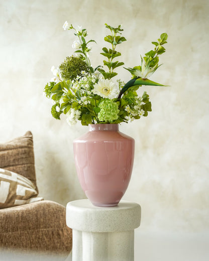 De roze vaas Rosa van Fan of Flowers in maat M, gevuld met het stijlvolle zijden boeket Niva, op een betonnen sokkel.