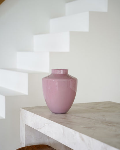 Een lege, glanzend roze vaas Rosa van Fan of Flowers, maat S, geplaatst op een marmeren bijzettafel met een witte achtergrond.