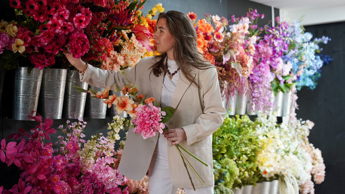 Femke Goossens kiest losse zijden bloemen uit de winkelvoorraad in haar atelier voor een unieke restyle.