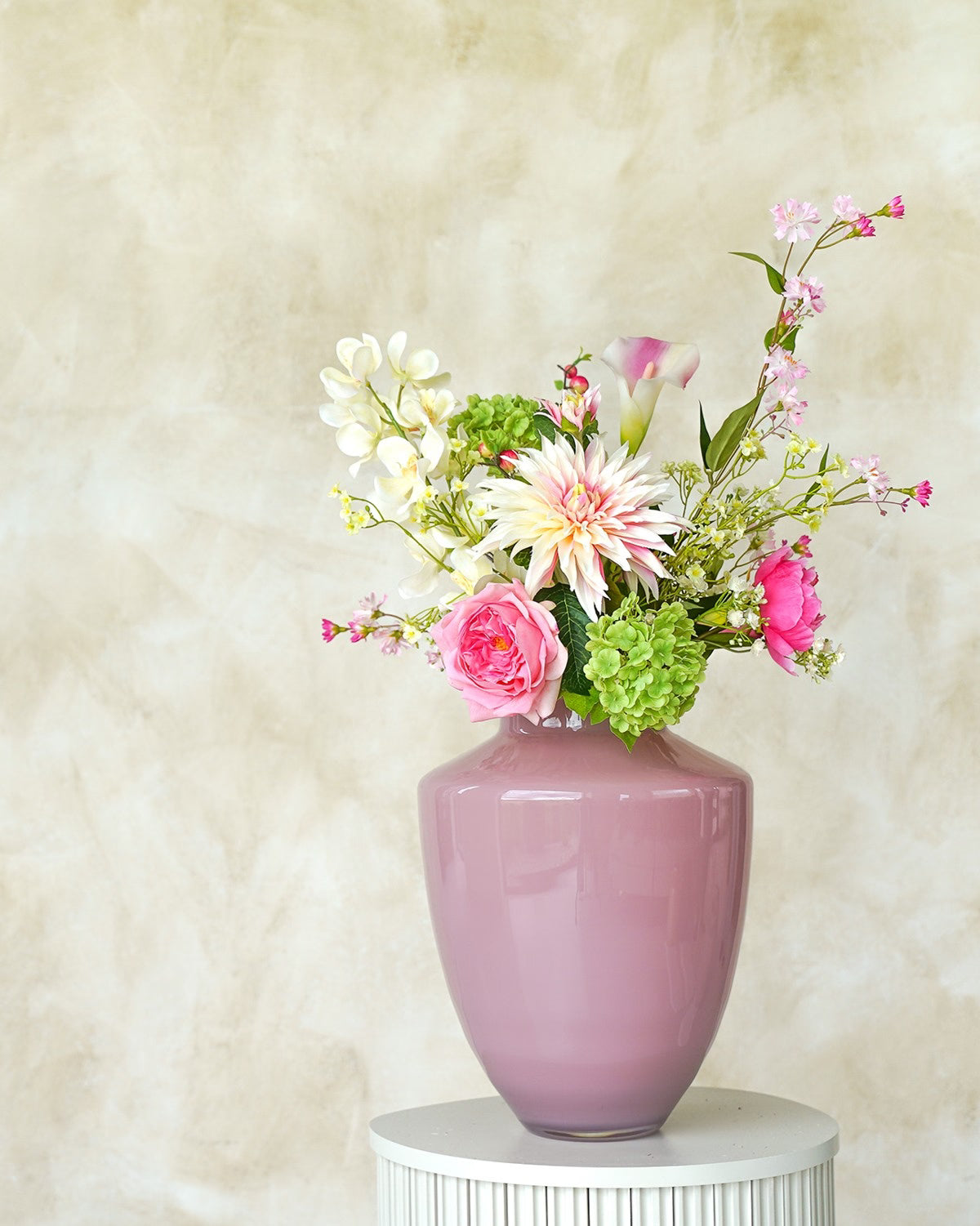 Een kleurrijk zijden boeket Lola gepresenteerd in de zacht roze vaas Rosa van Fan of Flowers