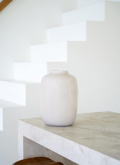Luxe crème-witte vaas Crema M van Fan of Flowers, leeg gepresenteerd op een stijlvol marmeren meubel.