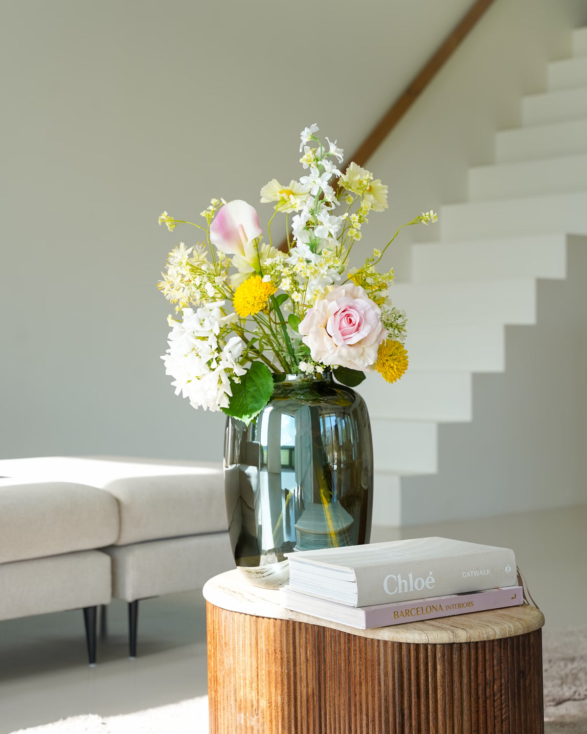 Zijden Boeket Luz met gele, witte en zachtroze bloemen in Vaas Glossy M op een houten salontafel.