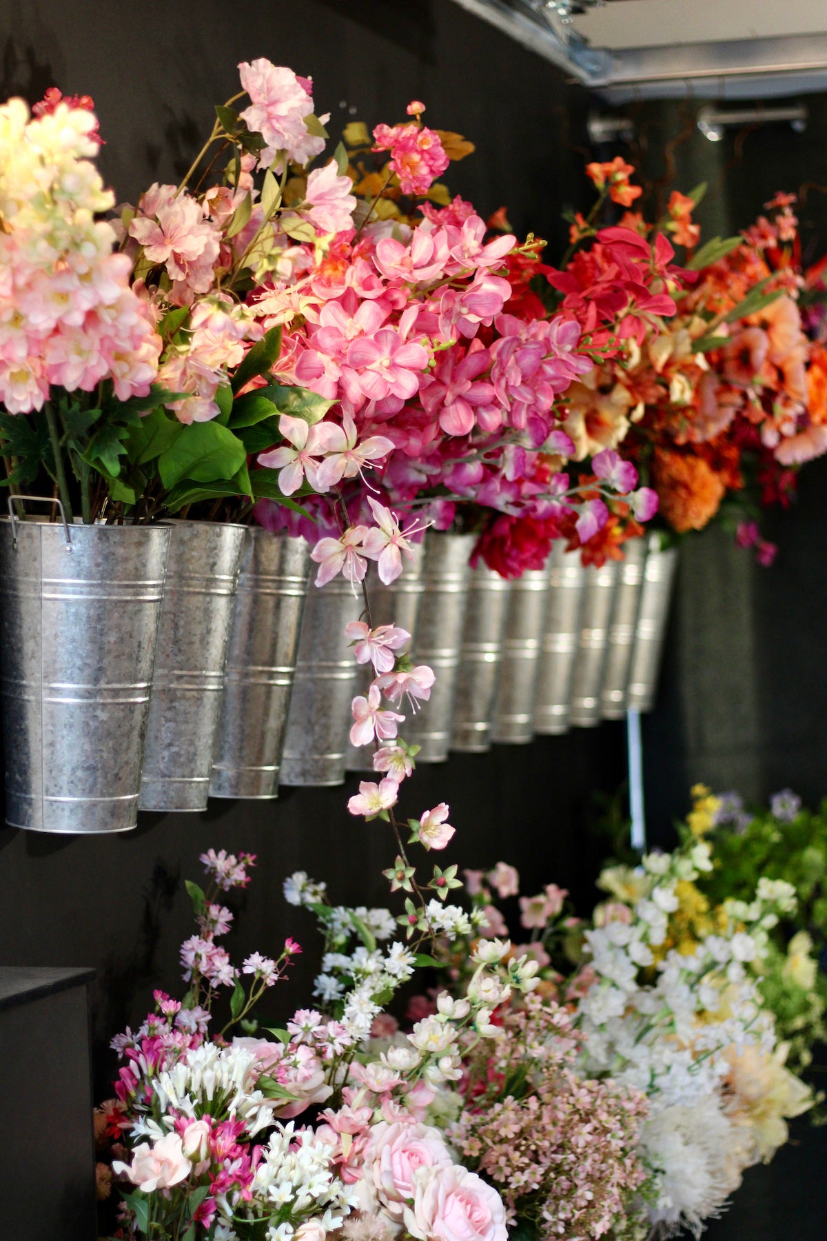 Wandvoorraad van Fan of Flowers met talloze zinken koven vol losse zijden bloemen en kunststelen voor maatwerk boeketten.