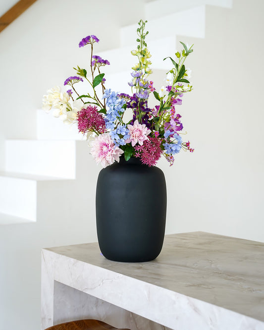 Stijlvol kleurrijk zijden boeket Amatista van Fan of Flowers elegant gepresenteerd in matzwarte vaas Negro.