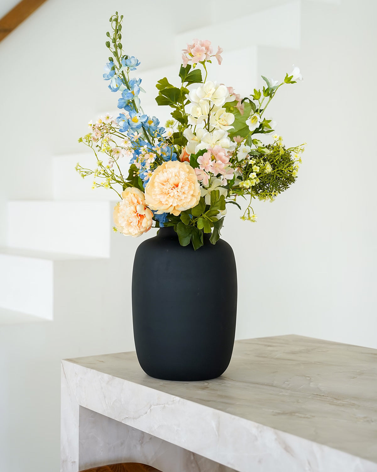 Stijlvol pastelkleurig zijden boeket Brisa van Fan of Flowers gepresenteerd in matzwarte vaas Negro.