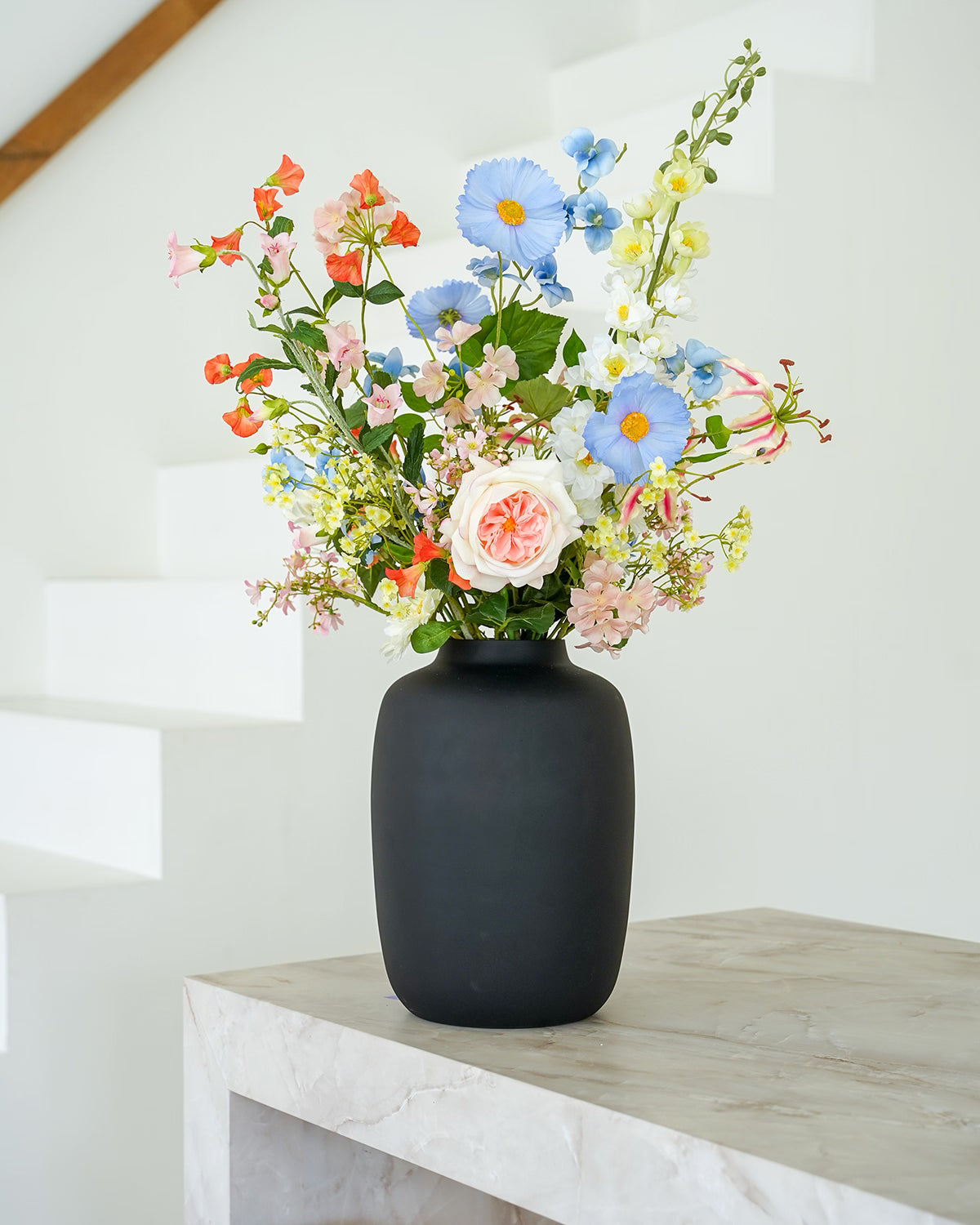 Pastelkleurig zijden boeket Mari van Fan of Flowers stijlvol gepresenteerd in matzwarte vaas Negro.