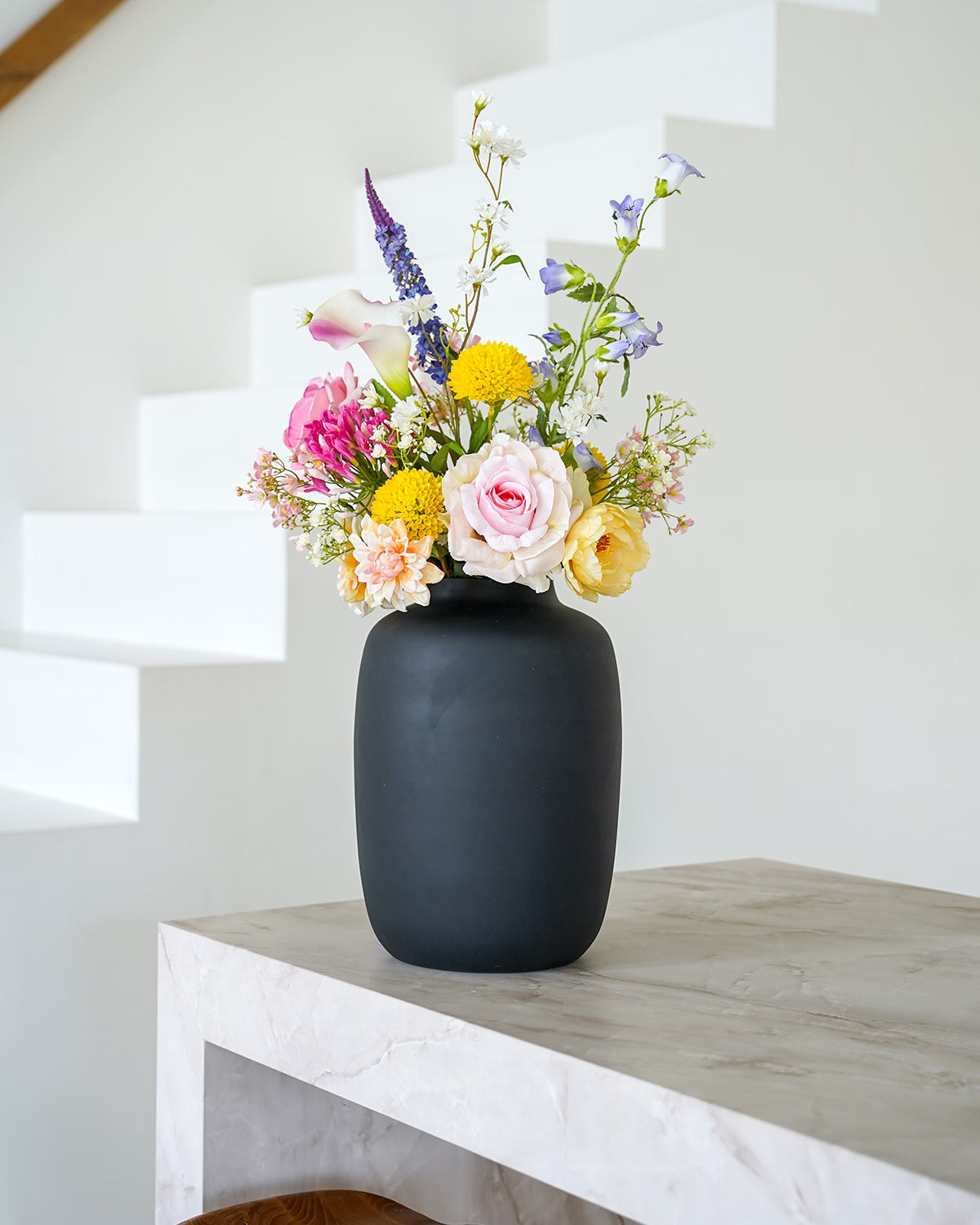 Stijlvol zijden boeket Nina van Fan of Flowers gepresenteerd in de matzwarte vaas Negro.