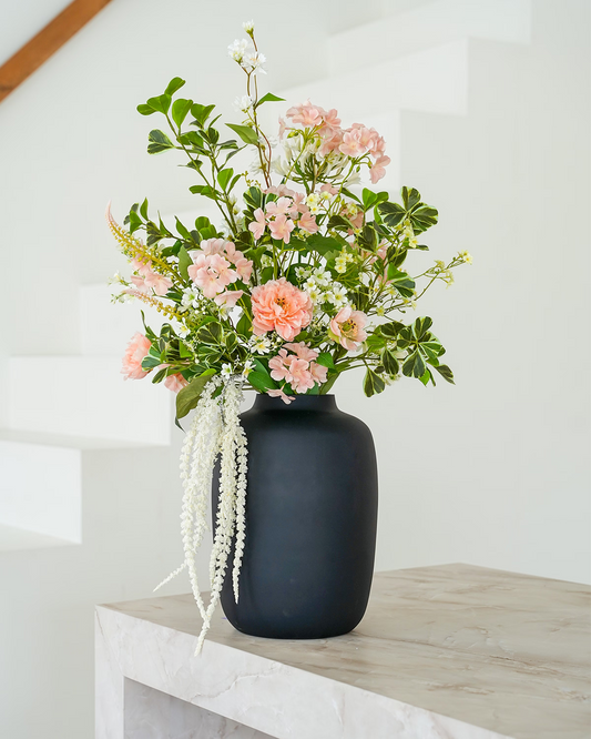 Stijlvol zachtroze zijden boeket Perla van Fan of Flowers elegant gepresenteerd in matzwarte vaas Negro.