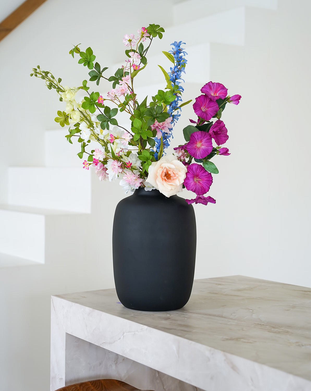 Stijlvol paars met blauw zijden boeket Rosa van Fan of Flowers gepresenteerd in matzwarte vaas Negro.