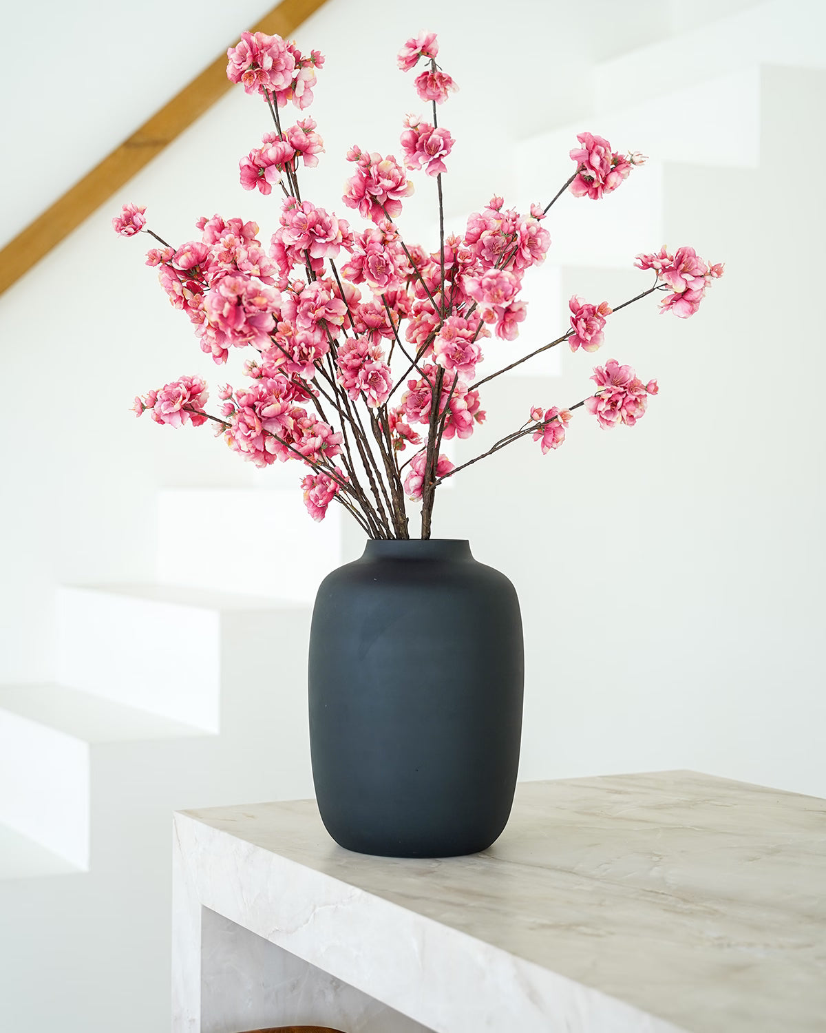 Donkerroze zijden bloesem takken in matzwarte Vaas Negro M van Fan of Flowers