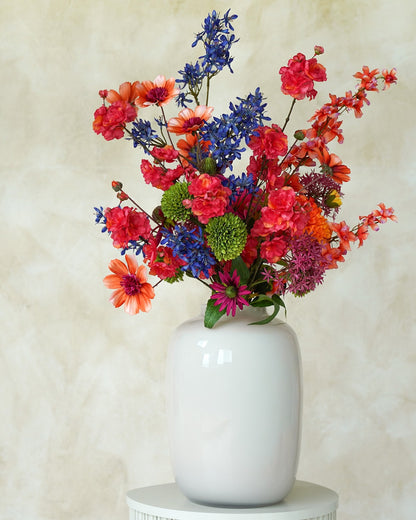 Kleurrijk zijden veldboeket Cielo van Fan of Flowers gepresenteerd in glanzend witte vaas Crema.