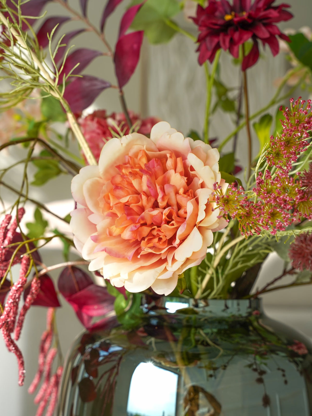 Detail van een crèmekleurige zijden bloem met een perzikkleurig hart, omringd door fijne roze bloemetjes in boeket Lila van Fan of Flowers.