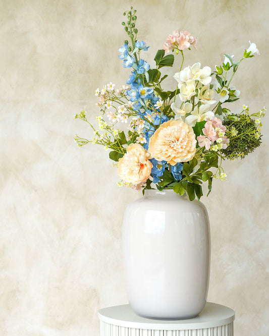 Sfeervol zijden boeket Brisa met zachte pioenen uit de collectie van Fan of Flowers gepresenteerd in vaas Crema.