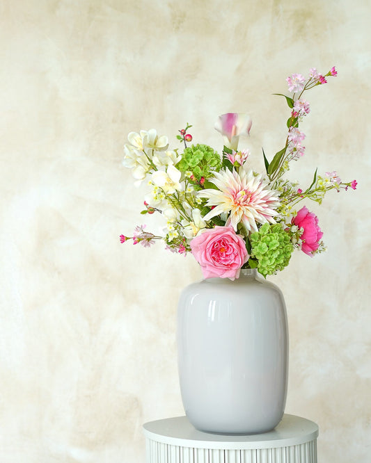 Een prachtig kunstboeket Lola, onderdeel van de collectie zijden boeketten van Fan of Flowers, in de glanzende vaas Crema.