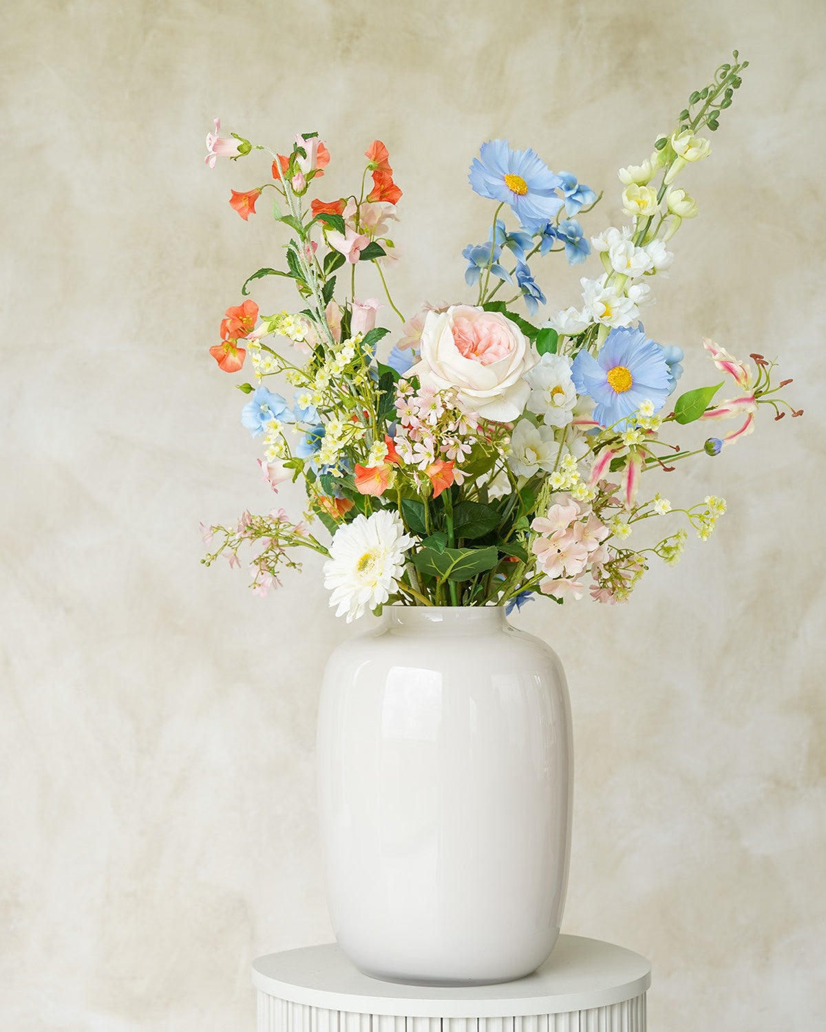 Sfeervol zachtblauw en pastelkleurig zijden boeket Mari uit de collectie van Fan of Flowers gepresenteerd in vaas Crema.