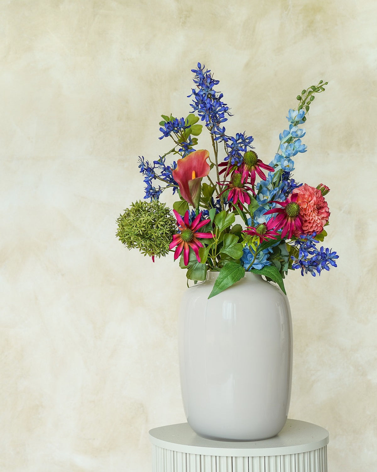 Kleurrijk zijden boeket Rubi uit de collectie kunstboeketten van Fan of Flowers in vaas Crema.