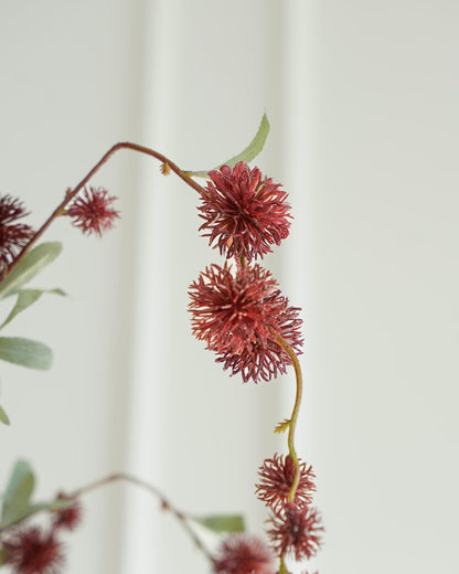 Detail van bruine bolletjes met bordeauxrode nuances en grijsgroene blaadjes aan een zijden tak van Fan of Flowers.