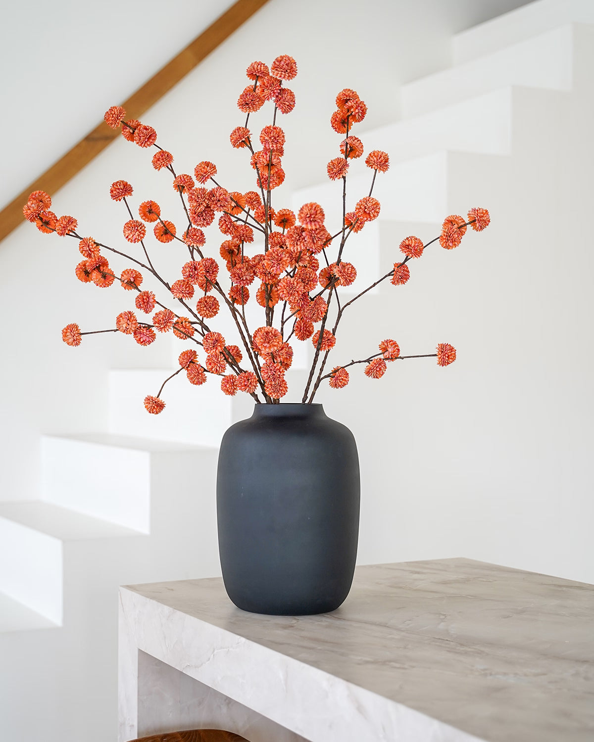 Oranje zijden pompom takken in matzwarte Vaas Negro M van Fan of Flowers